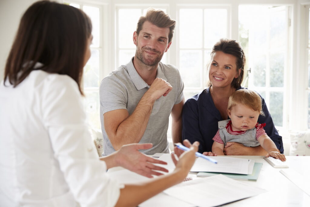 young couple with baby consulting with realtor